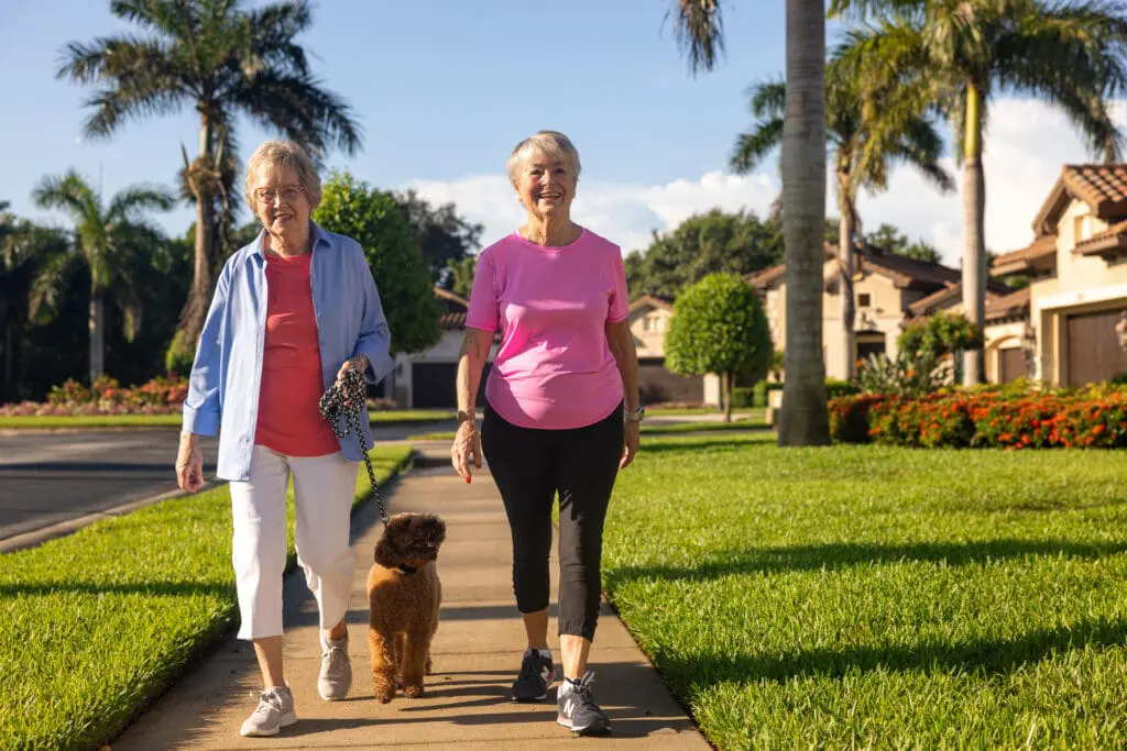 Two senior women taking a dog for a walk at The Arlington