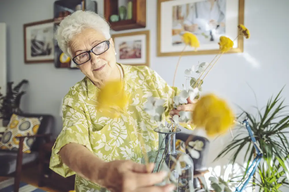 a senior woman arranging flowers in her apartment