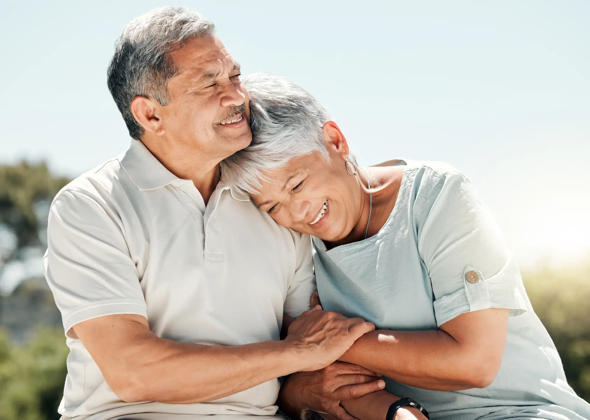 A elderly happy couple hugging on a beach, near The Arlington of Naples, an independent living community in Naples, FL.