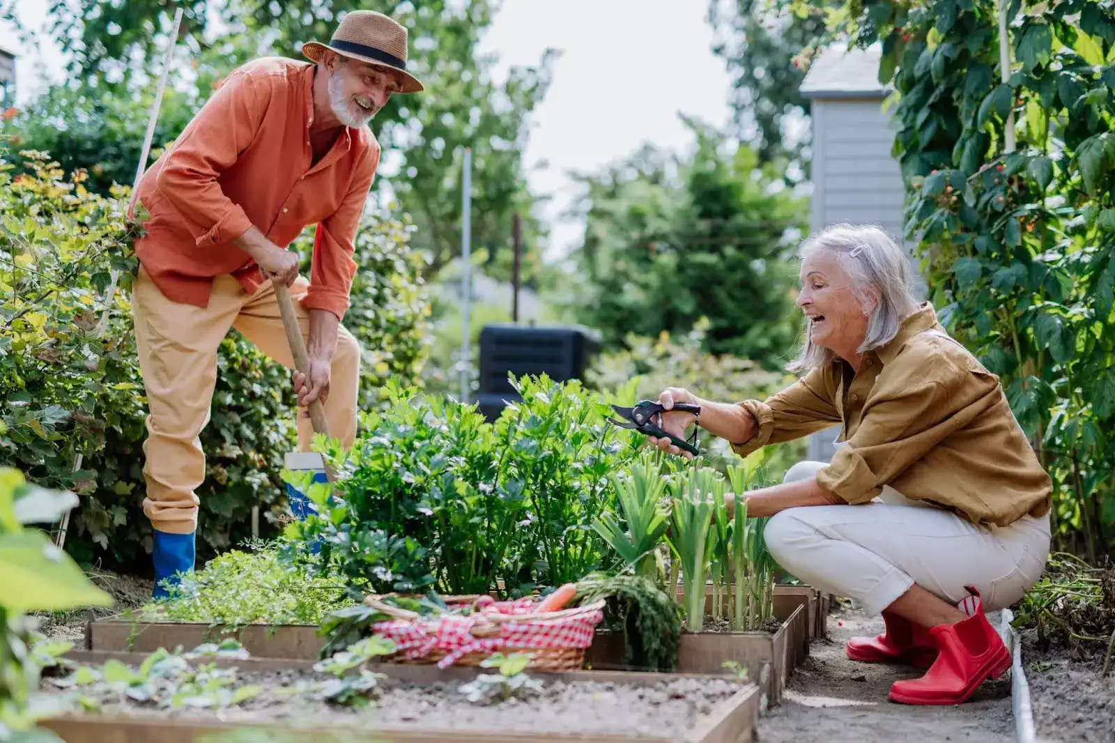 A senior couple gardening while talking about how Life Plan Community benefits extend far beyond care and financial savings into a vibrant, active lifestyle. 