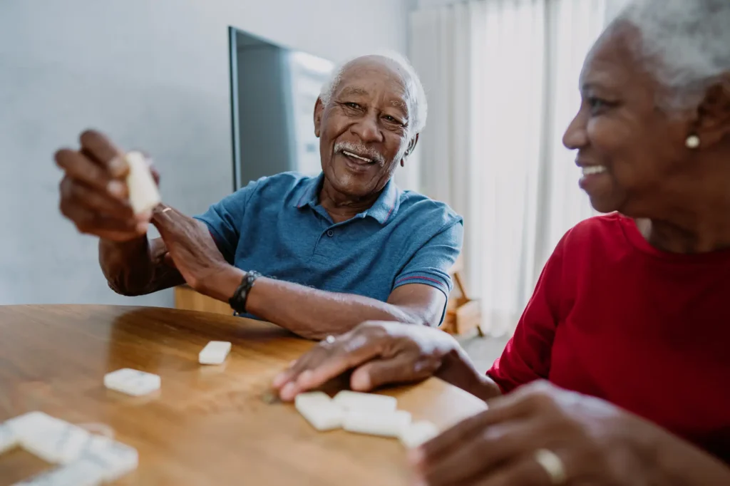 A senior couple playing dominos, a great short-term memory game at The Arlington Of Naples In Florida.