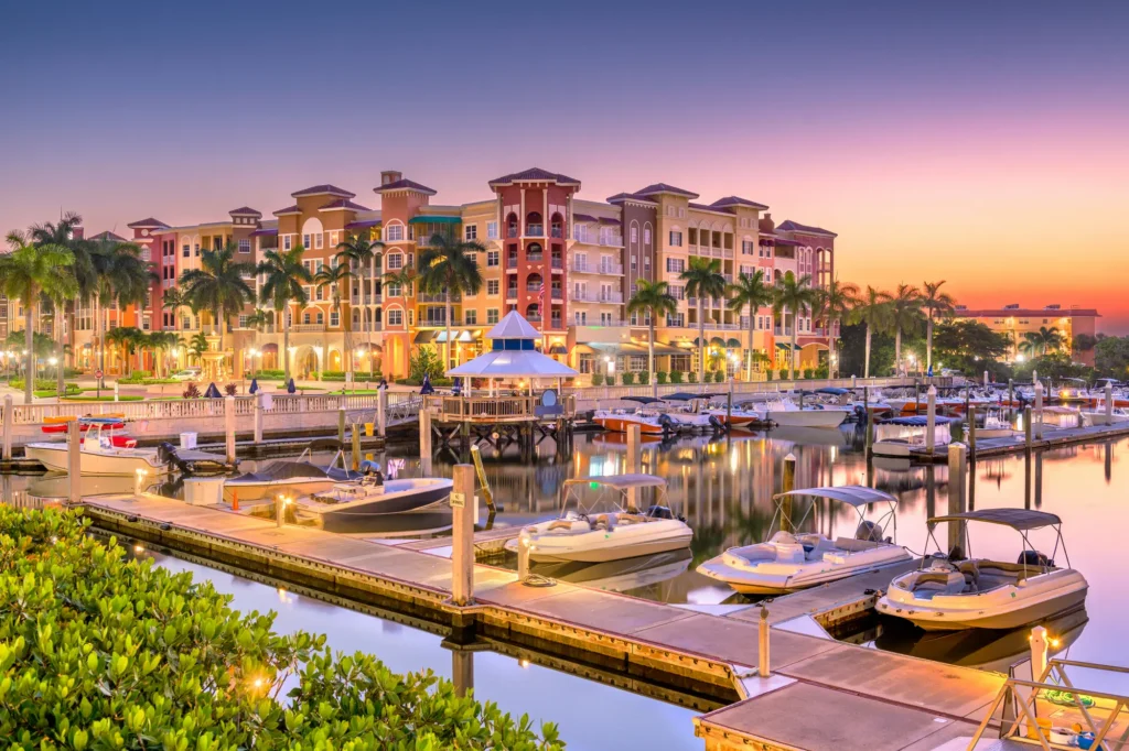 A wide shot of downtown Naples, Florida, featuring buildings and a dock for boats.